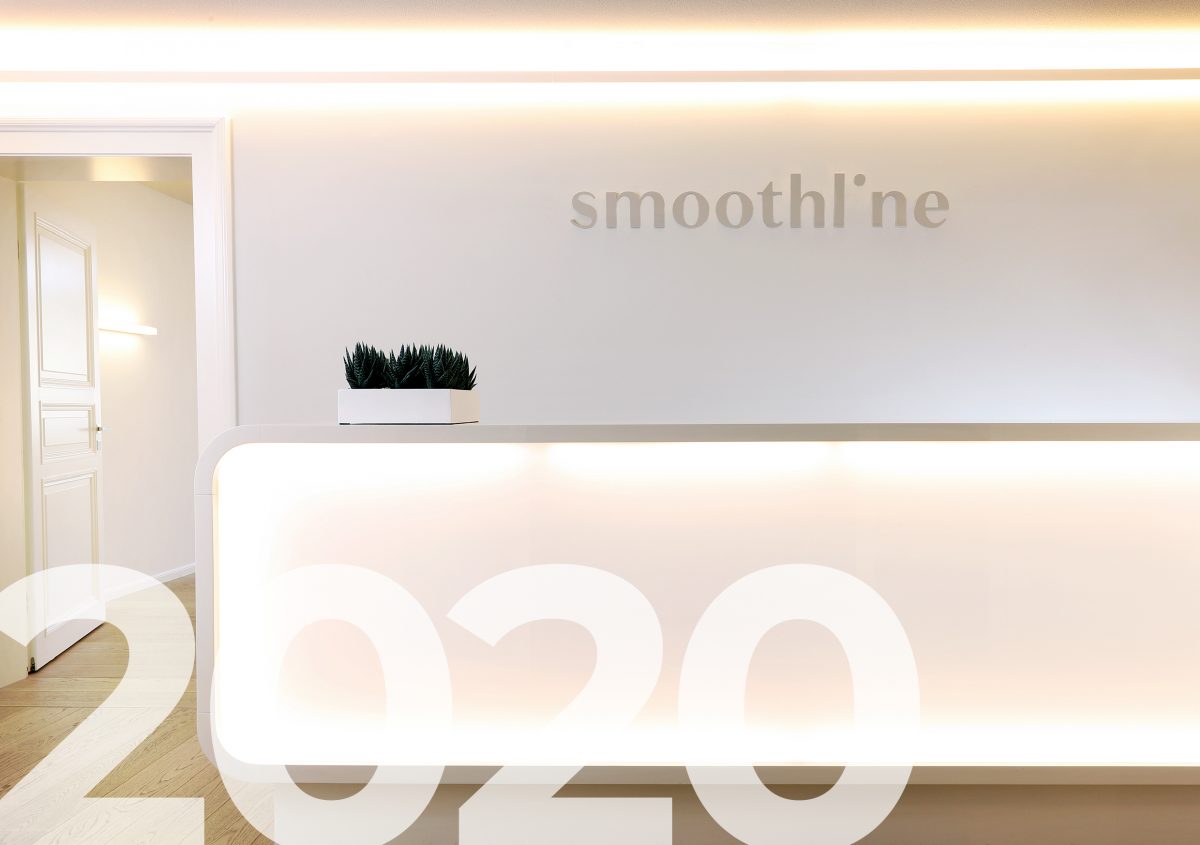 Foto des Empfangsdesks der Smoothline Praxis nach dem Re-Design des Logos mit der Jahreszahl 2020 als Grafik im Vordergrund.