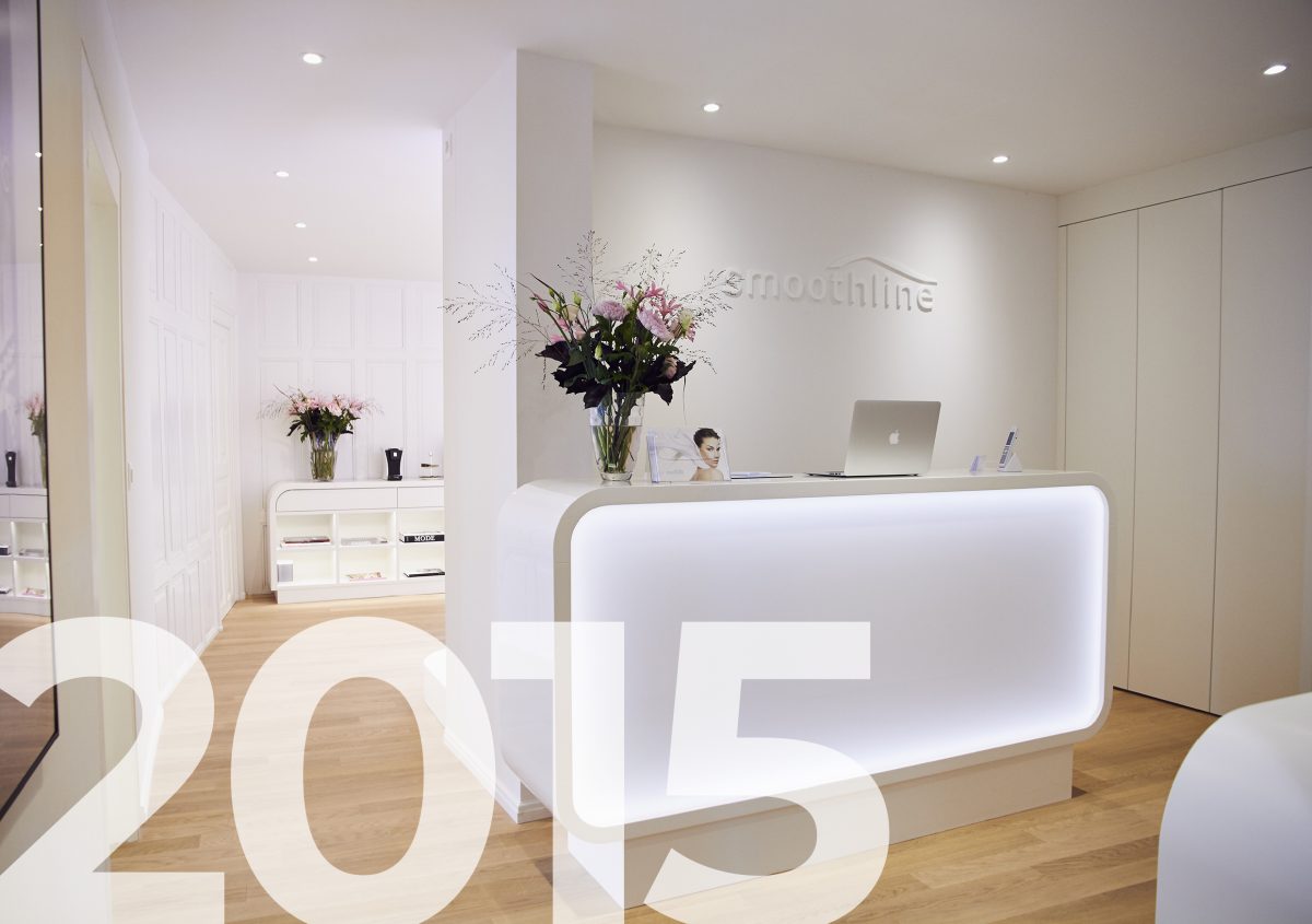 Foto des Empfangsdesks der Smoothline Praxis in Winterthur mit der Jahreszahl 2015 als Grafik im Vordergrund.