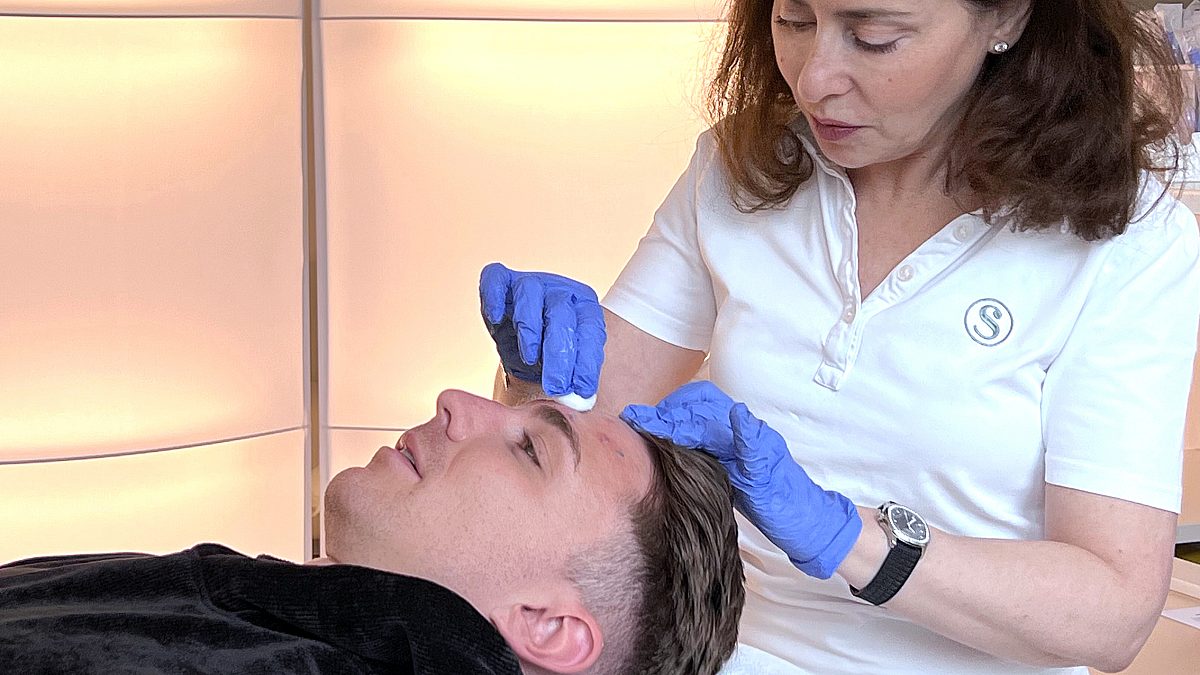 Photo of Dr. med. Olga Juri disinfecting the areas of Nicolo's face to be treated with Botulinum toxin